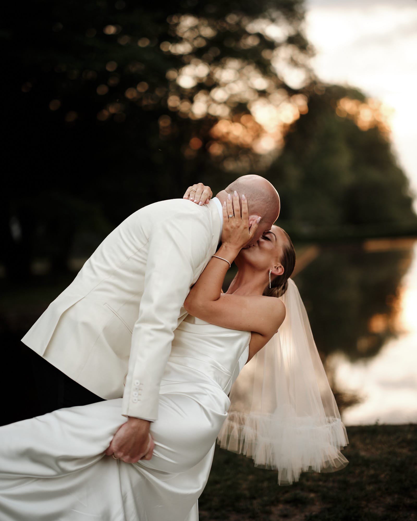 Wedding couple kissing outdoors in warm evening light