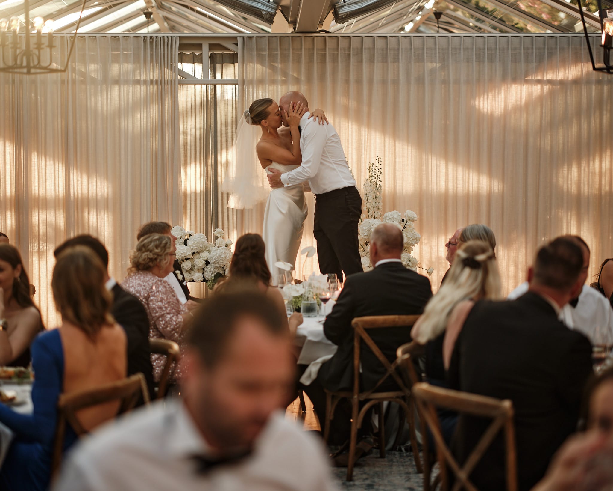 Wedding couple kissing during an elegant dinner celebration in Denmark