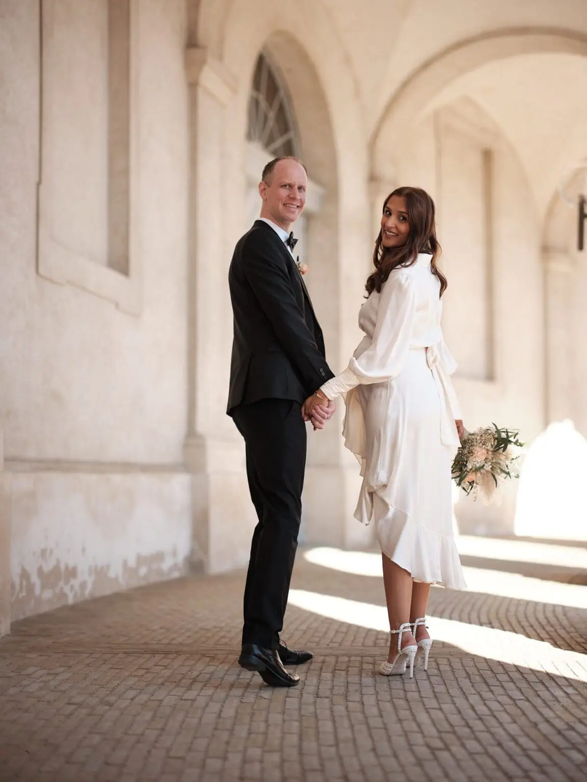 Bride and groom holding hands for a portrait near the Riding Grounds at Christiansborg Palace, Copenhagen.