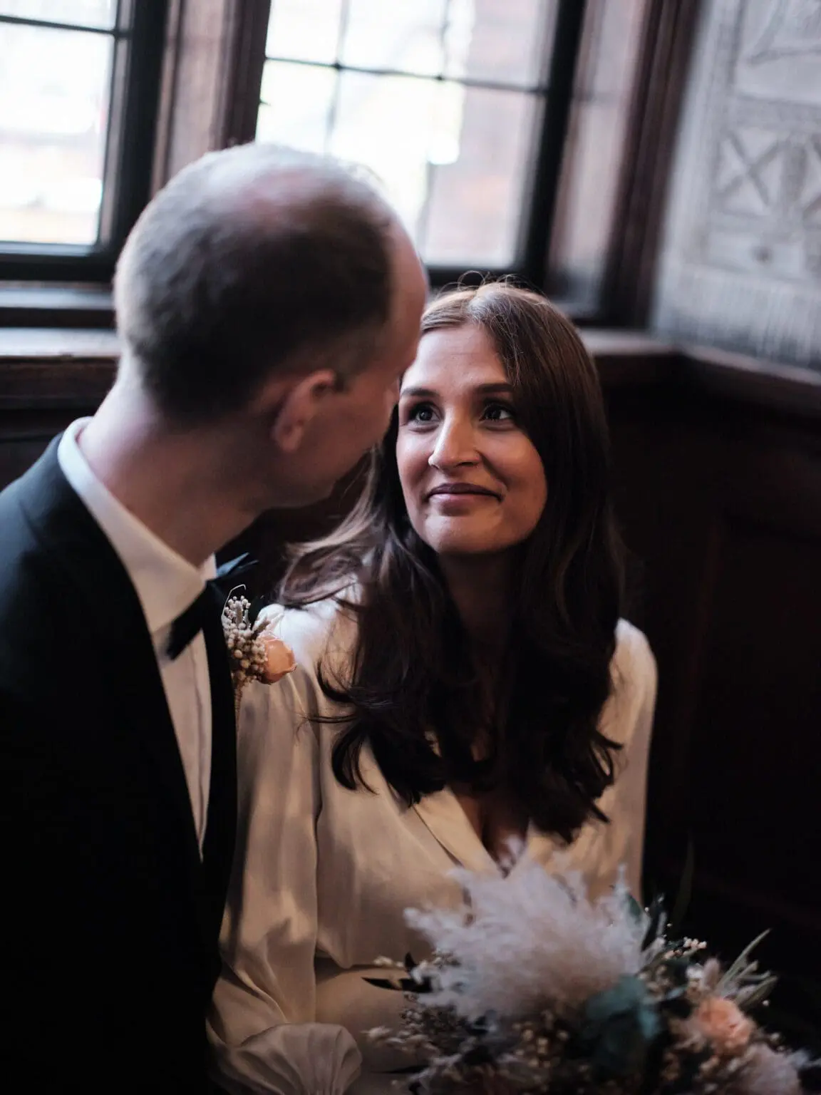 Bride gazes lovingly at groom in a quiet moment at Copenhagen City Hall, preserved by Nordic Wedding Photography.