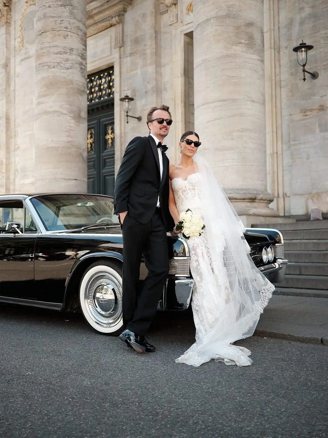 Stylish couple by vintage car captured by Nordic Wedding wedding photographer